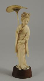 OKIMONO en ivoire sculpté figurant une élégante relevant de la...