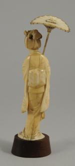 OKIMONO en ivoire sculpté figurant une élégante relevant de la...