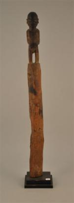 POTEAU-FETICHE en bois sculpté à sa partie supérieure d'un homme,...