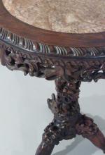 GUÉRIDONcirculaire en bois exotique richement sculpté. Le plateau à marbre...