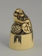 NETSUKE CACHET ovale en ivoire sculpté d'un chien de Fô...