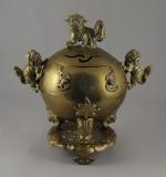 BRÛLE-PARFUM en bronze de forme boule sur un piétement tripode,...