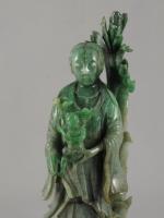 STATUETTE en jade représentant un personnage portant un enfant. Dans...
