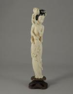 OKIMONO en ivoire sculpté figurant une femme tenant d'une main...