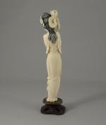 OKIMONO en ivoire sculpté figurant une femme tenant d'une main...