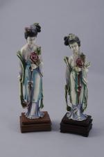 Deux STATUETTES en ivoire sculpté polychrome représentant une femme tenant...