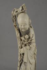 SUJET en ivoire figurant Shou Lao appuyé sur son bâton....
