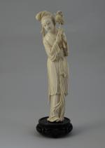 STATUETTE en ivoire figurant une femme montrant une fleur d'éternité....