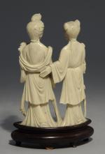 STATUETTE en ivoire sculpté représentant deux femmes, l'une tenant un...