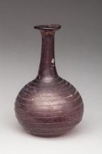 BALSAMAIRE. Verre aubergine. Filets de verre.Ier-IIème siècle après J.-C.Haut. 9...